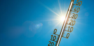 Ein Thermometer wird in die Sonne gehalten