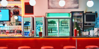 EIne 80er Jahre Retro Bar mit alten Barhockern und leuchtenden Kühlschränken
