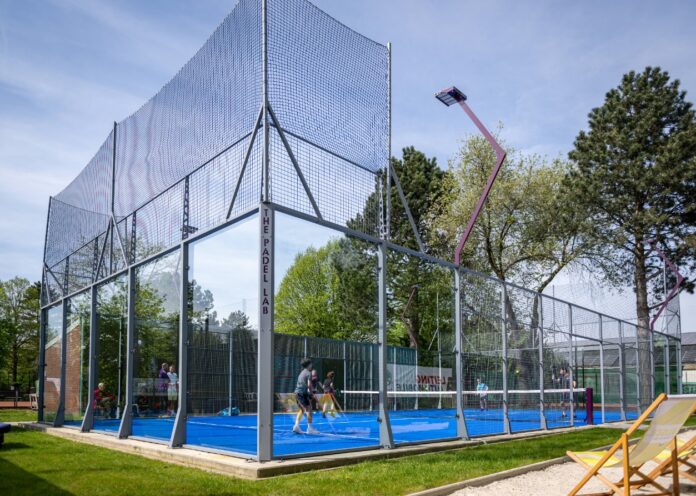 Ein eingezäunter Tennisplatz und Tennisspieler in Action