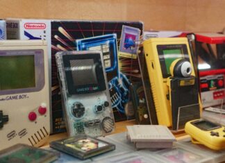 Es stehen viele, alte Spielkonsolen nebeneinander. Davor liegen die passenden Spiele dazu.