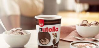 Eine neue Eiskreation der Marke Nutella steht auf einem Tisch neben Haselnüssen. Es ist eine Haselnuss- und Kakao-Eiscreme mit gefrorenen Nutellaschichten.