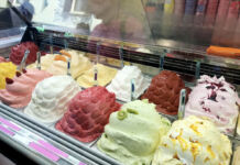 Eine Verkaufstheke in einem Eiscafé oder einer Eisdiele mit verschiedenen Eissorten wie Vanilleeis, Milcheis, Schokoladeneis, Fruchteis, Sorbet und anderes Speiseeis.