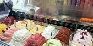 Eine Verkaufstheke in einem Eiscafé oder einer Eisdiele mit verschiedenen Eissorten wie Vanilleeis, Milcheis, Schokoladeneis, Fruchteis, Sorbet und anderes Speiseeis.