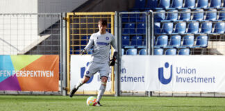 Max Weiß ist 19 Jahre alt und kickt für den Karlsruher SC. Er steht im Tor und hat hier ein weißes Trikot und eine weiße kurze Hose an. Ebenso trägt er als Torhüter des KSC Handschuhe.