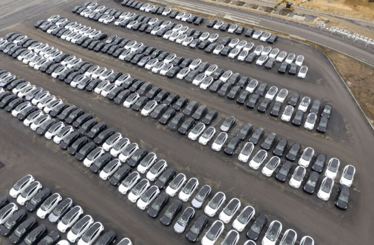 Auf einem großen Parkplatz stehen viele Autos ordentlich nebeneinander. Die Fahrzeuge haben unterschiedliche Farben. Es handelt sich dabei um PKWs und Elektroautos, die neu und gebraucht aussehen.