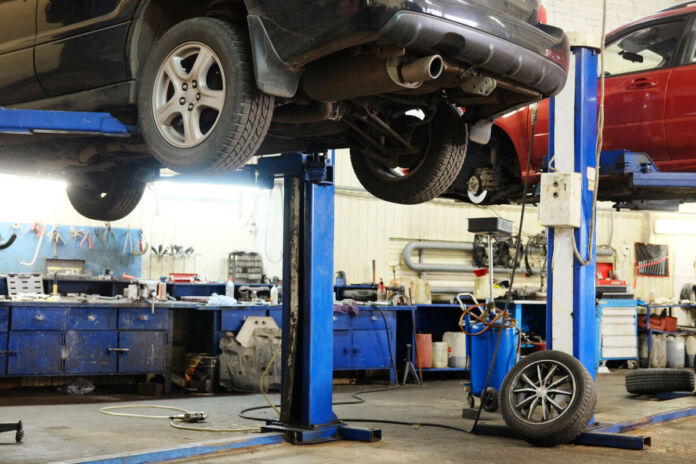 Ein Auto wird in einer Werkstatt repariert. Es handelt sich um die Reparatur eines Verbrennungsmotors in einer offiziellen Kfz-Werkstatt. Reparaturkosten für E-Autos sind sehr viel höher.