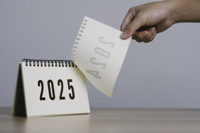 Eine Hand reißt an einem schlichten Tischkalender das Kalenderblatt des Jahres 2024 ab, sodass das Kalenderblatt für das Jahr 2025 sichtbar wird. Das neue Jahr hat begonnen. Die Frist für Bürger läuft.