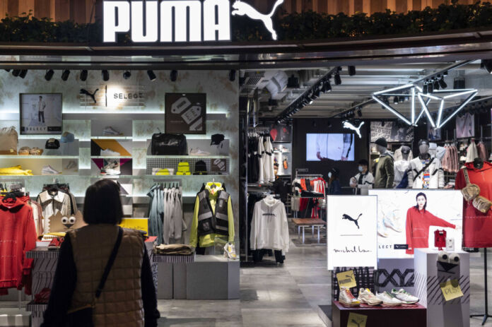Ein großes Geschäft des Bekleidungs-Riesen und Sportfachgeschäfts Puma ist von vorne zu sehen. Man sieht viele Klamotten und andere mit Sport verbunden Waren.