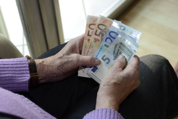 Ein Rentner hält sein Geld für den Monat in der Hand. Viele ältere Menschen haben zu wenig Bargeld zur Verfügung und kommen nicht über die Runden. Sie leben an der Armutsgrenze.