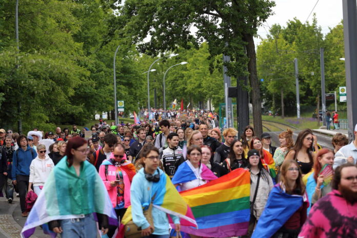 Viele Menschen laufen in einem Umzug mit Regenbogenflagge auf dem Christopher Street Day durch die Straßen, um für die Rechte von Schwulen, Lesben und Transpersonen zu demonstrieren. Der CSD ist eine der größten Demos des Landes.