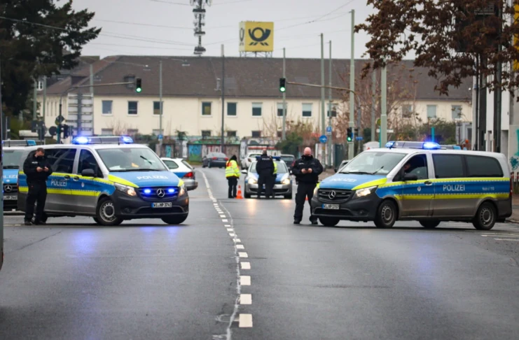 polizei KMRD entschärfung evakuierung bombenentschärfung absperrung mannschaftswagen polzeiauto straßensperre Kampfmittelräumdienst Einsatzbereich Sicherheitszone Sperrkreis Zwei Mannschaftswagen der Polizei stehen quer auf der Straße, um eine Sperrzone einzurichten und das betroffene Gebiet abzusperren. Verschiedene Polizisten und Beamte stehen auf dabei, um den Vorgang zu überwachen. Es handelt es sich um eine Evakuierung wegen eines möglichen Bombenfunds in einer Karlsruher Schule.